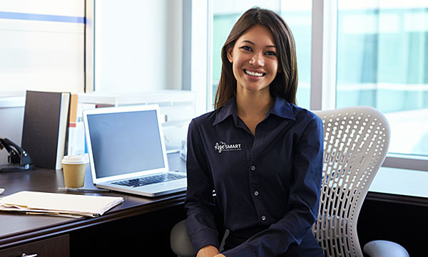 Smiling AgeSMART lifestyle concierge team member at desk representing personalized senior support