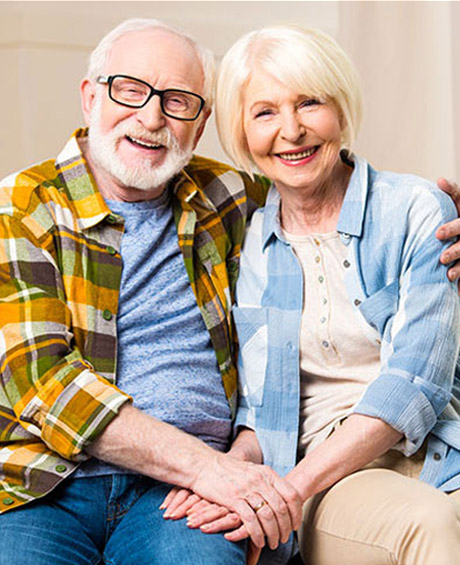 Smiling senior couple sitting together representing answers to common questions about coordinated senior care services