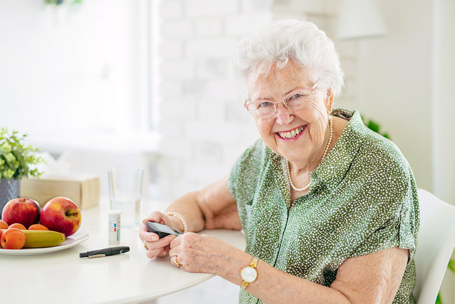 Senior woman checking blood sugar at home