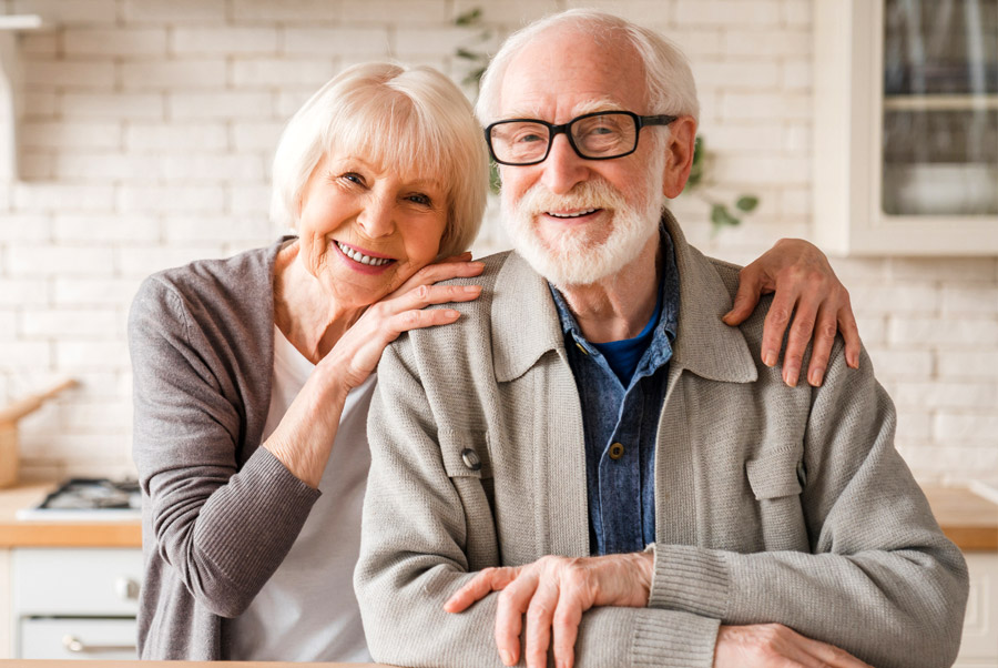 Smiling senior couple embracing at home together