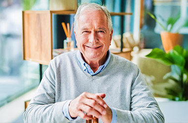 Smiling senior man sitting comfortably at home enjoying independent living