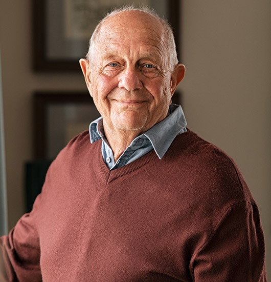 Smiling senior man standing comfortably at home enjoying independent living

