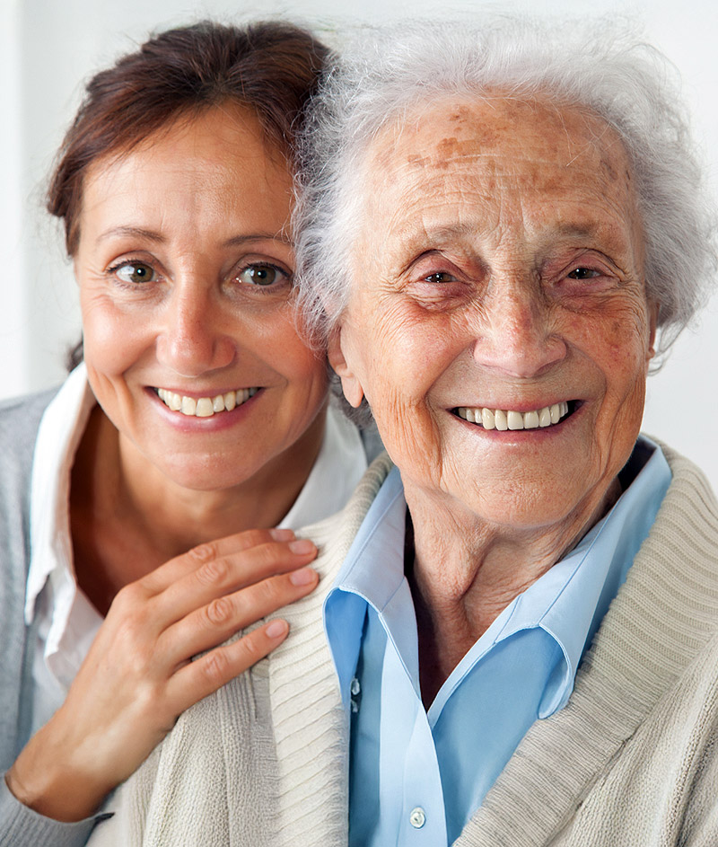 Happy female caregiver with smiling senior woman.
